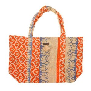 May include: A large tote bag made from recycled fabric. The bag has a beige background with orange and blue patterned stripes. The bag has two long straps.