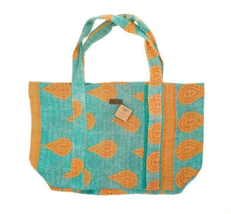 May include: A turquoise and orange tote bag with a paisley pattern. The bag has two long straps and a small tag with the word "OX" on it.