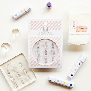 May include: A collection of hand gesture stamps, a clear stamp block, and several white highlighters with colored dots. The stamp set is packaged in a box with the text "SPLICE STAMP" and "Let your creativity flow with Splice Stamp". A small paper with the text "Today is your day!" is also present.