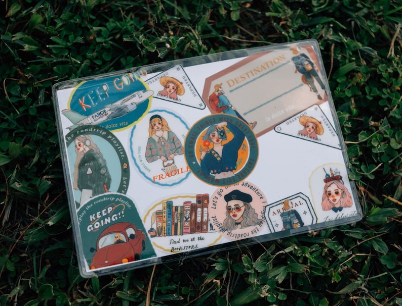 May include: A set of colorful stickers with illustrations of people, airplanes, books, and text that says "Keep Going!" and "Destination: Adventure".