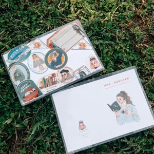 May include: Two clear plastic sheets with colorful stickers and illustrations. The top sheet has stickers with text like "Keep Going!" and "Destinations". The bottom sheet has a drawing of a person reading a book.