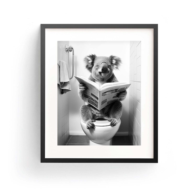 Puede incluir: Una impresi&oacute;n art&iacute;stica enmarcada en blanco y negro que muestra a un koala sentado en un inodoro blanco mientras lee un peri&oacute;dico abierto. El koala tiene orejas esponjosas y est&aacute; en un ba&ntilde;o con azulejos y una toalla colgada en la pared.
