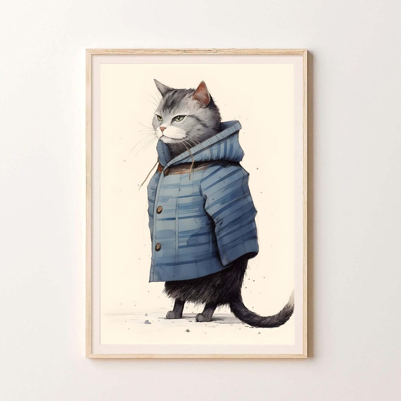 May include: A framed wall art print featuring a grey tabby cat wearing a blue hooded duffle coat with toggle buttons. The cat is depicted in profile, standing on a light cream background. The wooden frame surrounds the illustration.