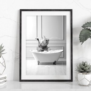 Pu&ograve; includere: Una fotografia in bianco e nero di un rinoceronte che fa il bagno in una vasca da bagno bianca. Il rinoceronte &egrave; nella vasca con la testa e le spalle sopra l'acqua. C'&egrave; uno spruzzo d'acqua che esce dal rubinetto.