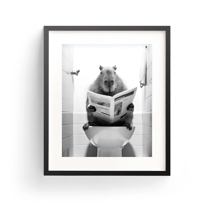 May include: A black and white photo of a capybara sitting on a toilet and reading a newspaper.