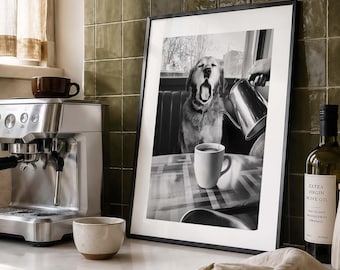 May include: A framed black and white photograph depicting a dog yawning while a hand pours liquid from a metal kettle into a white mug on a table. The print is displayed in a thin black frame, capturing a scene of a dog sitting at a booth table.