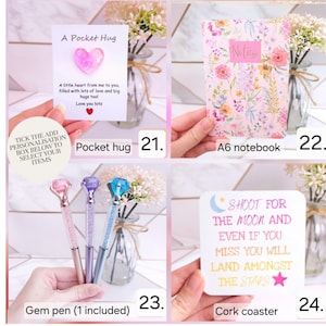 Pode incluir: Uma cole&ccedil;&atilde;o de quatro itens: um cart&atilde;o Pocket Hug com um cora&ccedil;&atilde;o rosa, um caderno A6 floral com o texto Notes, tr&ecirc;s canetas com gema em rosa, roxo e azul, e um porta-copos de corti&ccedil;a quadrado com o texto Shoot for the moon and even if you miss you will land amongst the stars.