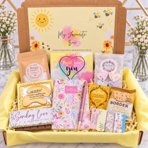 Pode incluir: Uma caixa de presente contendo um sachê de sais de banho Relax, máscaras de ouro para os olhos Aliver, um caderno floral com uma caneta rosa, um cartão Just for you, chá Pukka, biscoitos Border, marcadores magnéticos e uma barra de chocolate.