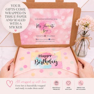 Pode incluir: Uma caixa de presente de cart&atilde;o castanho com a tampa aberta apresentando um padr&atilde;o de cora&ccedil;&otilde;es cor-de-rosa e o texto My Favourite Box. No interior, papel de seda cor-de-rosa claro cobre o conte&uacute;do com um cart&atilde;o de Happy Birthday. Um vaso de vidro com flores cor-de-rosa est&aacute; ao lado.