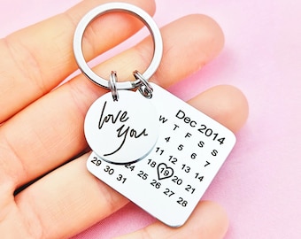 May include: Silver keychain with a round charm that says "love you" and a square charm with a calendar for December 2014 with the 19th circled and a heart over it.
