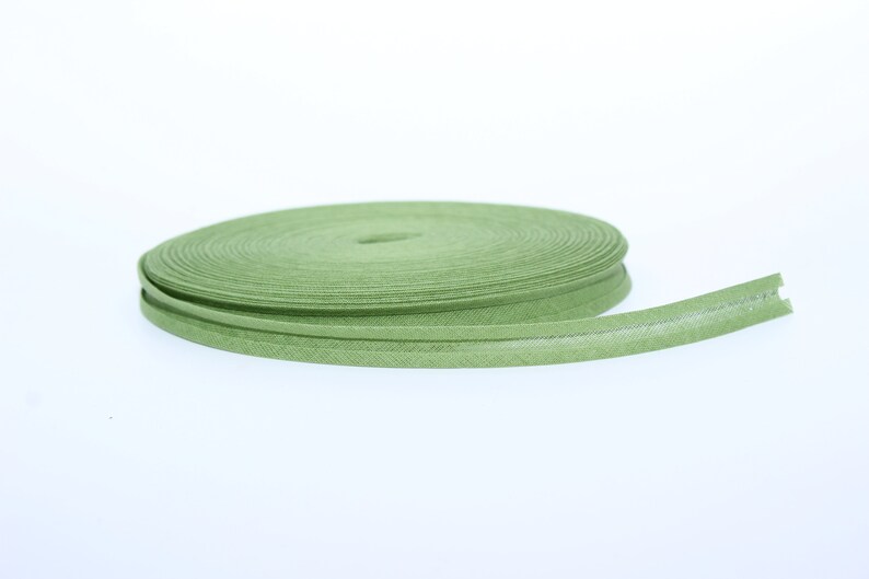 Puede incluir: Un rollo de ribete de tela verde con una superficie ligeramente texturizada.