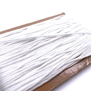 May include: A roll of white cord, tightly wound on a cardboard base. The cord is made of a smooth, synthetic material, suitable for various crafting and DIY projects. The bright white colour offers a clean, versatile appearance. The cord is measured in metres.