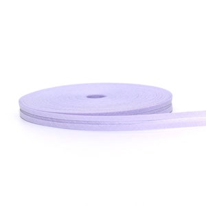 Puede incluir: Un rollo de cinta de color lavanda con acabado satinado. La cinta est&aacute; enrollada en espiral y est&aacute; lista para ser utilizada para manualidades o decoraci&oacute;n.