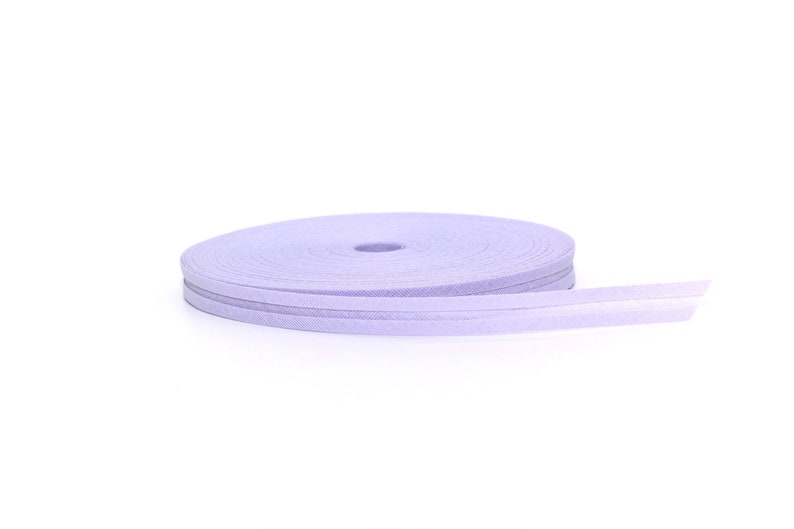 Puede incluir: Un rollo de cinta de color lavanda con acabado satinado. La cinta est&aacute; enrollada en espiral y est&aacute; lista para ser utilizada para manualidades o decoraci&oacute;n.