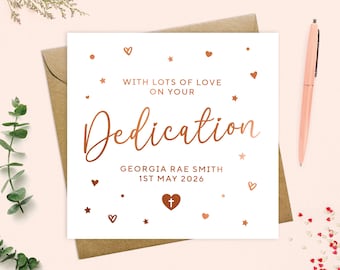 May include: A white card with a copper foil design. The card says "With lots of love on your Dedication" and "Georgia Rae Smith 1st May 2026".