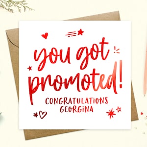 May include: A white card with red foil lettering that says "You got promoted! Congratulations Georgina". The card is decorated with red hearts and stars.