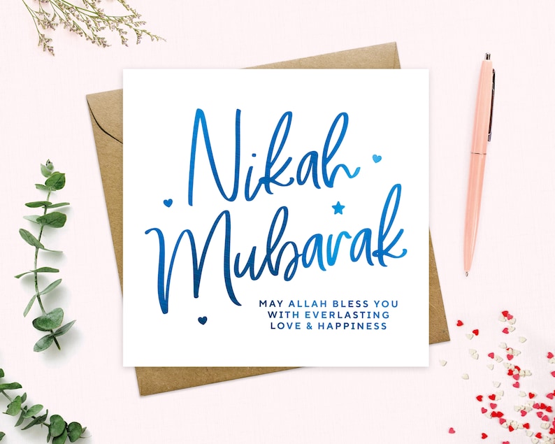 May include: A white card with blue calligraphy that says "Nikah Mubarak" and the text "May Allah bless you with everlasting love & happiness".