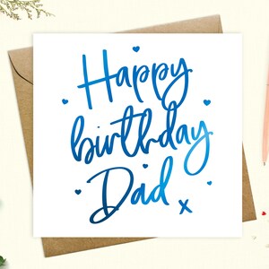 May include: A white card with blue foil lettering that says "Happy birthday Dad" with small hearts scattered around the text.