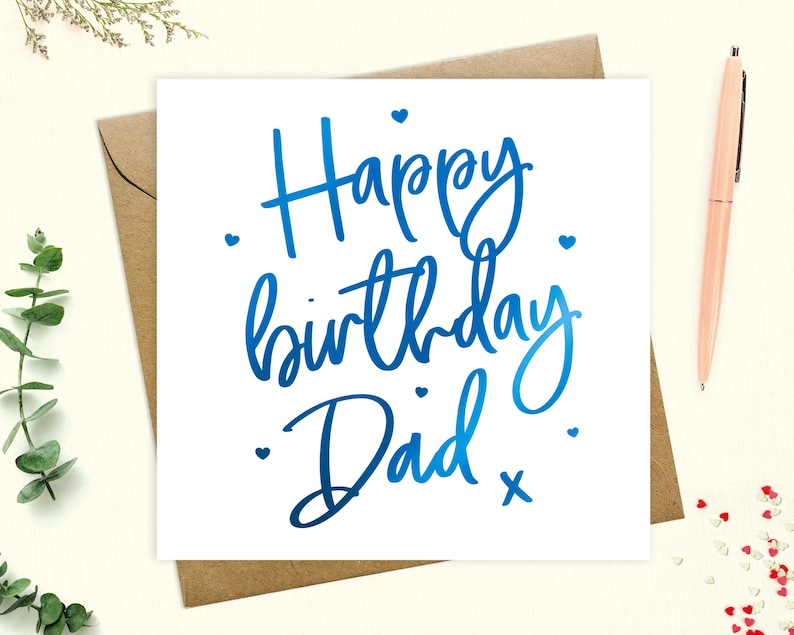 May include: A white card with blue foil lettering that says "Happy birthday Dad" with small hearts scattered around the text.