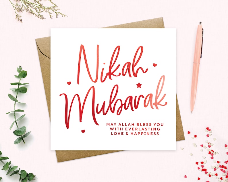 May include: A white card with red calligraphy that says "Nikah Mubarak" and the text "May Allah bless you with everlasting love & happiness".