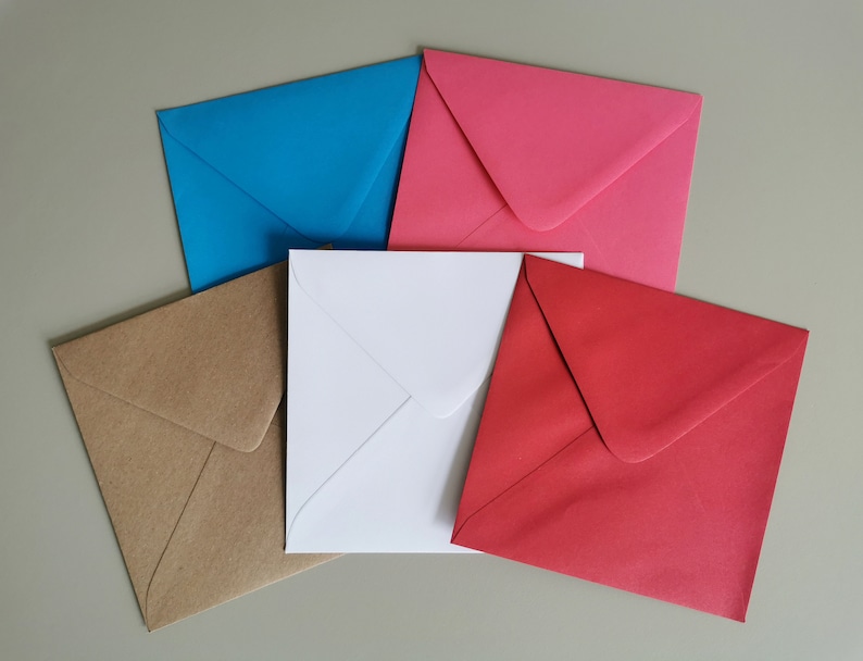May include: Five envelopes in different colors: brown, white, blue, pink, and red. The envelopes are all the same size and shape, and they are arranged in a semi-circle.