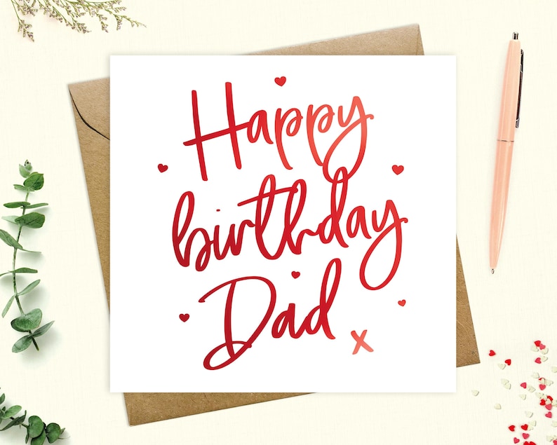 May include: A white card with red lettering that says "Happy birthday Dad" with a red heart and a red "x" at the end. There are small red hearts scattered around the text.