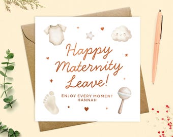 Może przedstawiać: Kwadratowa biała kartka z miedzianym napisem "Happy Maternity Leave!" i ilustracjami o tematyce dziecięcej. Karta zawiera body, odcisk stopy, grzechotkę i uśmiechniętą chmurkę, na brązowej kopercie.