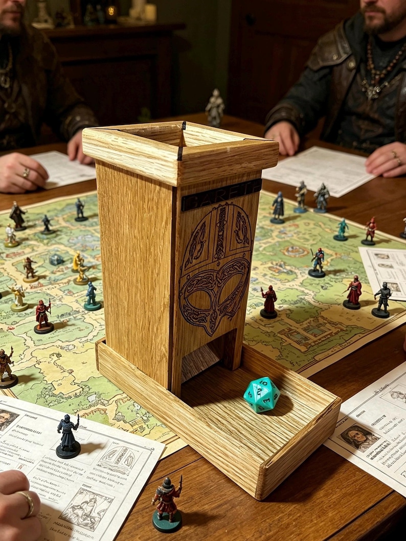 May include: A tall, light-colored wooden dice tower with a square top and a rectangular base tray. The front panel features a dark, engraved Viking-style helmet design and the word GARETH. A single turquoise twenty-sided die sits in the tray.
