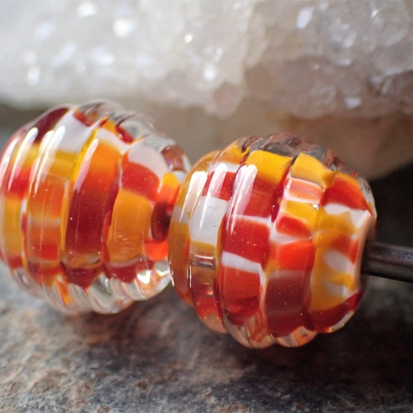 2 perles avec rainures en reliefs ivoire avec éclats de verre rouge orange et marron dans du verre transparent, verre de Murano