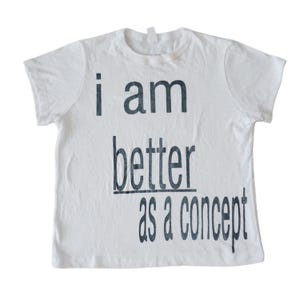 May include: White t-shirt with black text that reads "i am better as a concept".