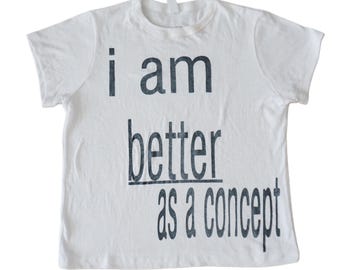 May include: White t-shirt with black text that reads "i am better as a concept".