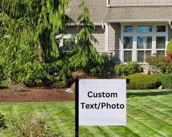 May include: Two white yard signs with black text. The sign on the left says "Custom Text/Photo". The sign on the right has a black and white soccer design with the text "Soccer" and a number. The signs are in front of a house with a green lawn.