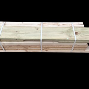 May include: A stack of wooden planks, bundled together with white straps. The planks are light brown and have a natural wood grain.