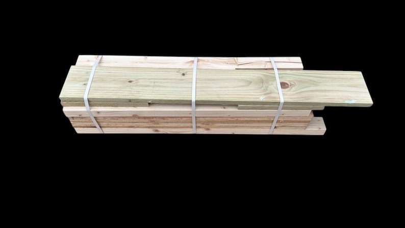 May include: A stack of wooden planks, bundled together with white straps. The planks are light brown and have a natural wood grain.