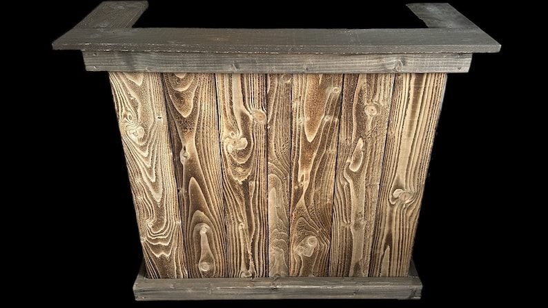 Op de afbeelding: Een rustieke houten bartafel met een donkerbruin gebeitst blad en een lichtbruine houten basis. De tafel is gemaakt van gerecycled hout met een natuurlijke houtnerf.