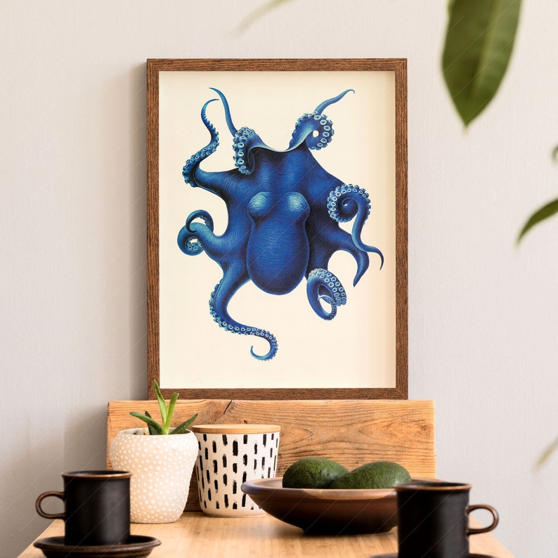 May include: A framed print of a blue octopus with white eyes and tentacles. The octopus is on a white background. The frame is brown wood.
