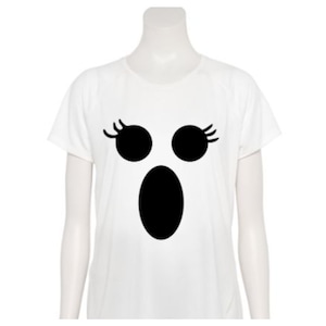 May include: A white short-sleeved t-shirt featuring a black graphic of a ghost face with circular eyes, eyelashes, and an oval mouth. The bottom right corner displays a purple logo with the letters KJ and the text Katie Jane Designs.