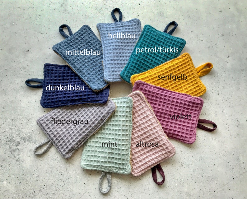 May include: Nine pot holders in various colors, including mint, pink, purple, yellow, blue, and gray. Each pot holder has a waffle-like texture and a loop handle.