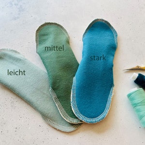 Peut inclure: Trois coussinets en tissu de diff&eacute;rentes nuances de vert et de bleu, &eacute;tiquet&eacute;s "leicht", "mittel" et "stark".