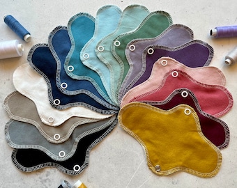 Protector diario fino y sostenible, disponible en muchos colores lisos, confeccionado en franela 100% algodón con alas.