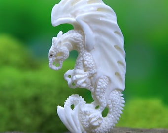 May include: A detailed, ivory-colored dragon figurine with outstretched wings. The dragon is carved with intricate scales and features, including a detailed head, claws, and a curled tail. The wings are large and flowing, adding to the fantasy theme.