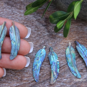 May include: Five iridescent blue and green abalone shell feather charms. The feathers are carved with detailed lines and have a natural, organic look.