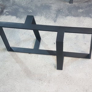 Peut inclure: Piètement de table en métal noir avec un design géométrique unique. Le piètement est composé de tubes carrés et a un aspect moderne et industriel.
