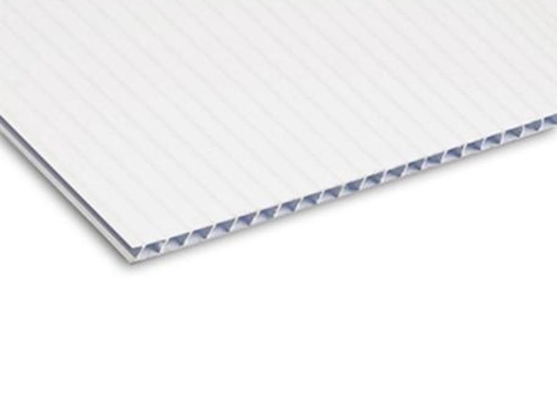 May include: A white corrugated plastic sheet with a ribbed surface. The edges reveal a honeycomb-like structure. The material appears to be lightweight and durable, suitable for signage or display purposes.