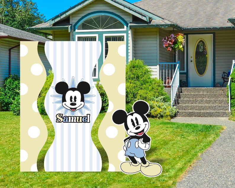 K&ouml;nnte beinhalten: Zwei gelbe und wei&szlig;e gestreifte Gartenschilder mit einem blauen und wei&szlig;en gestreiften Mittelteil. Der Mittelteil zeigt ein Cartoon-Bild von Mickey Mouse mit dem Namen "Samuel" darunter. Ein separates Gartenschild zeigt ein Cartoon-Bild von Mickey Mouse, der blaue Shorts tr&auml;gt.