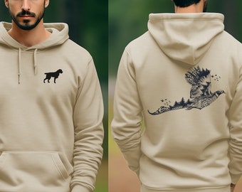 May include: A sand-colored hoodie with a black dog silhouette on the front and a black and white pheasant design on the back. The hoodie has a drawstring hood and a kangaroo pocket.