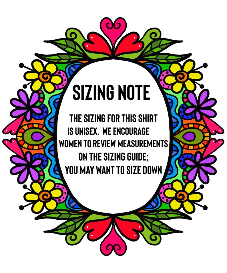 以下が含まれることがあります： 「SIZING NOTE」のテキストが入った白い楕円形。カラフルな花のボーダーで囲まれています。楕円内のテキストは、シャツがユニセックスであることを示し、サイズガイドで測定値を確認することを推奨しています。