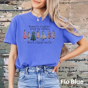Puede incluir: Camiseta azul con el texto "Women's rights vary by state. Men's rights don't." y un gr&aacute;fico de mujeres con vestidos. La camiseta es de color azul liso.