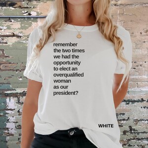 May include: White t-shirt with the text "remember the two times we had the opportunity to elect an overqualified woman as our president?" printed on the front.