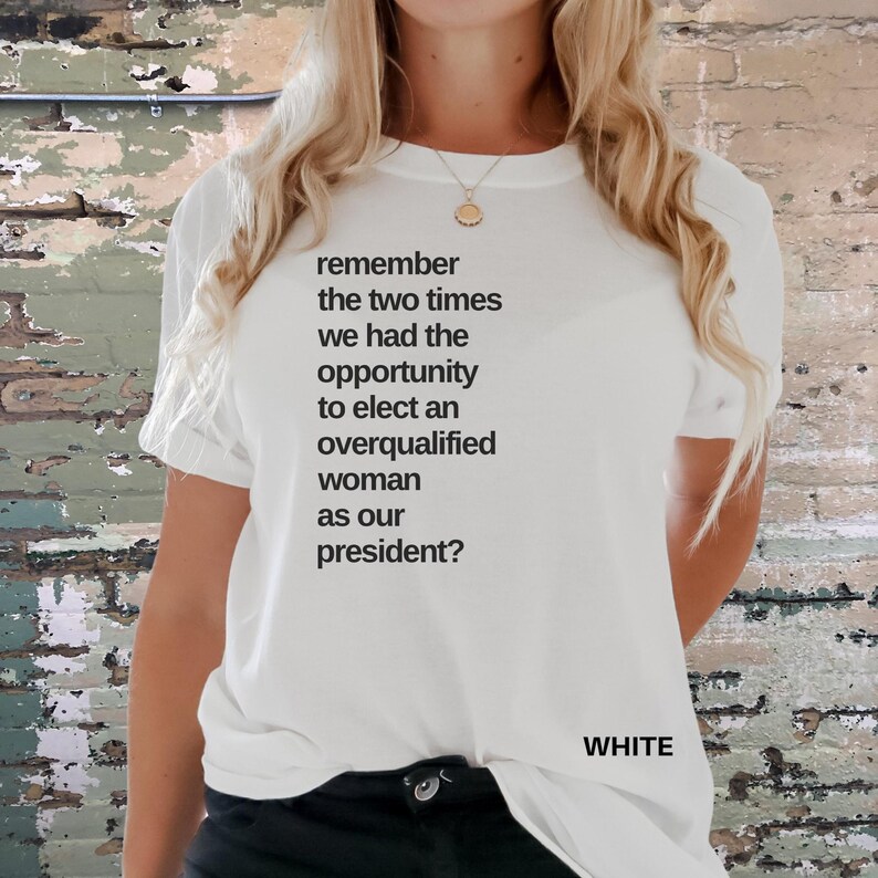 May include: White t-shirt with the text "remember the two times we had the opportunity to elect an overqualified woman as our president?" printed on the front.